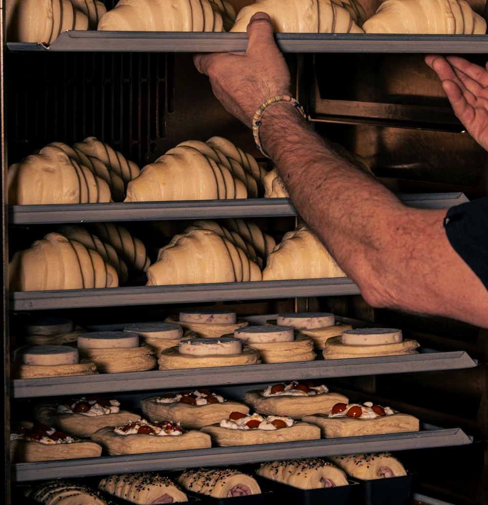 Un boulanger sort une plaque de croissants du four