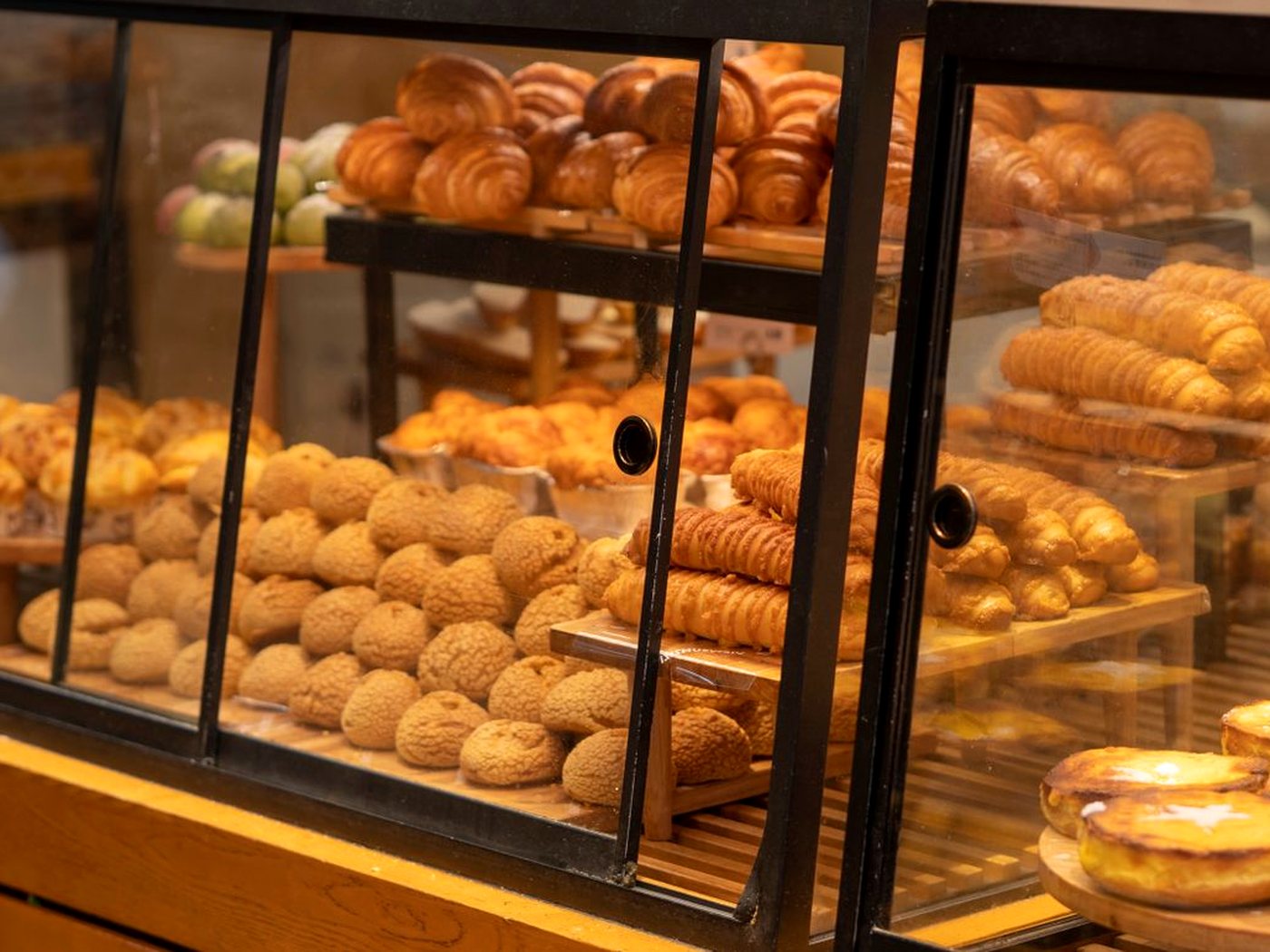 Des croissants, des choux et des cornets feuilletés dans la vitrine d’une boulangerie