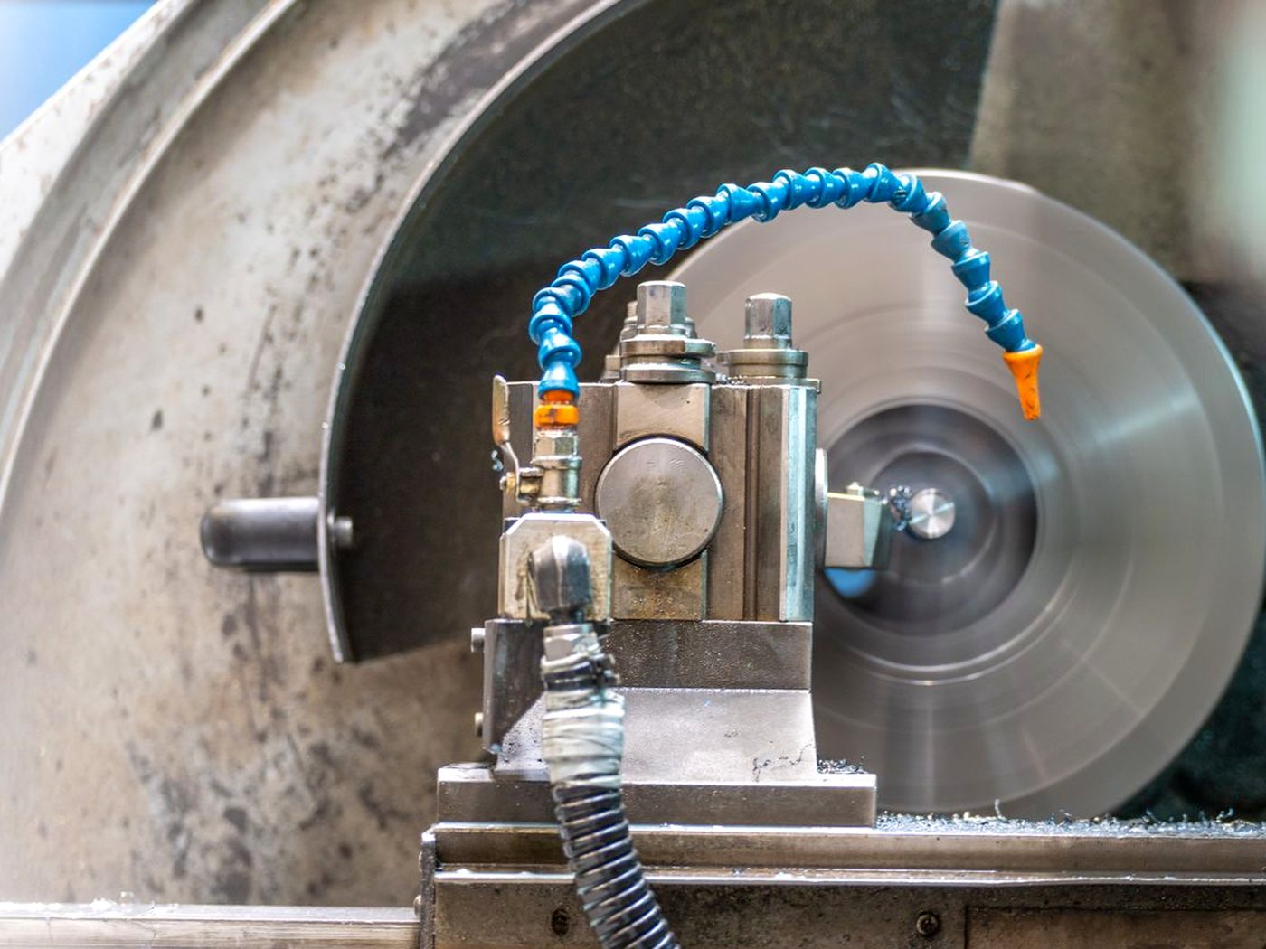Une machine d’usinage en marche avec son tuyau d’arrosage bleu articulé